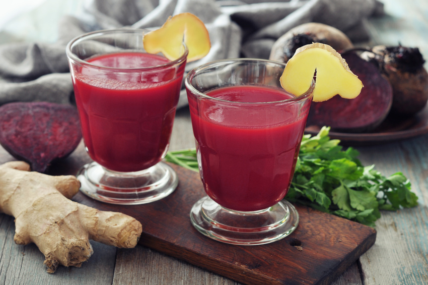 Beetroot smoothie in glass with ginger and fresh vegetables on wooden background