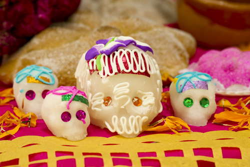 Calaveritas de azúcar decoradas con colores vivos sobre un altar de Día de Muertos
