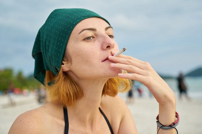 mujer fumando playa