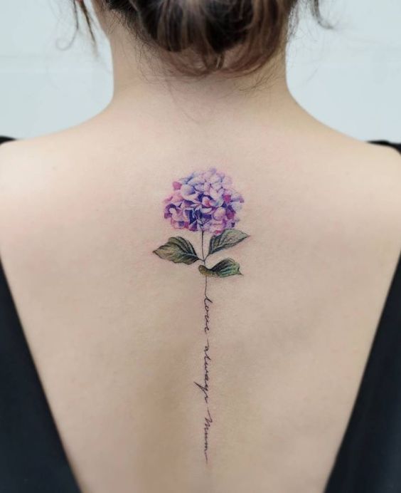 tatuaje de flores moradas con frase en cursiva
