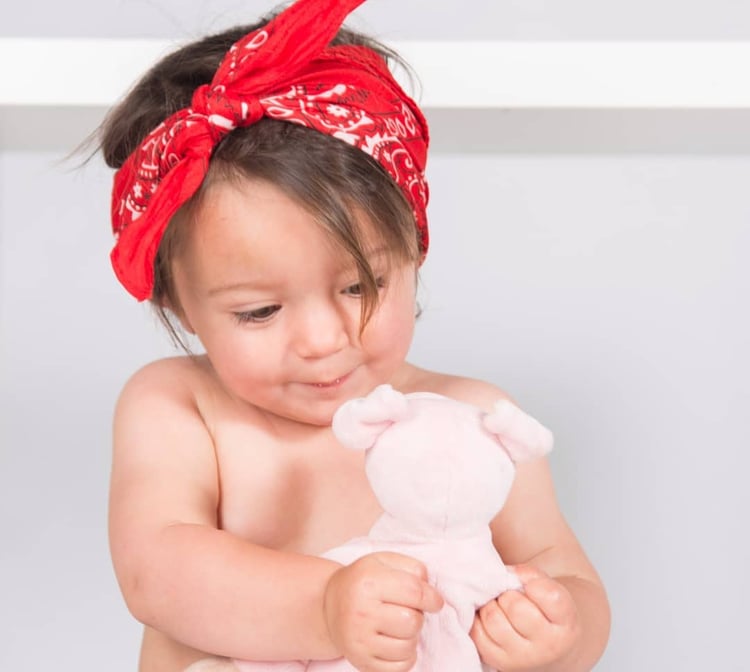 bebe jugando con peluche