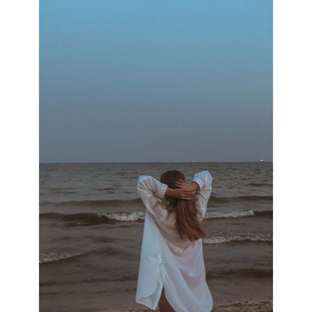 Chica en la playa tomando su cabello en la luna llena