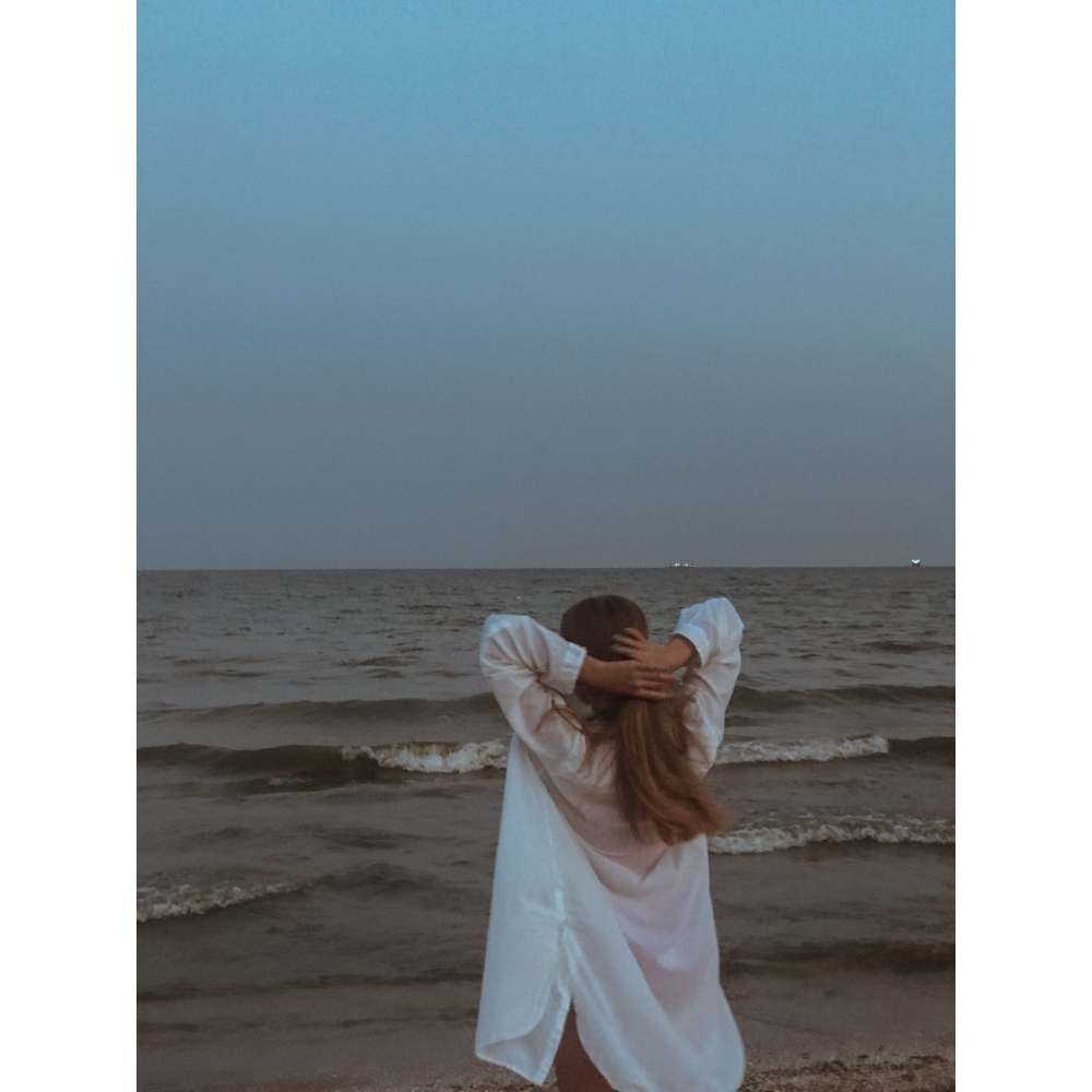 Las fases de la luna tienen efectos sobre nosotras y nuestro cuerpo Chica en la playa tomando su cabello en la luna llena