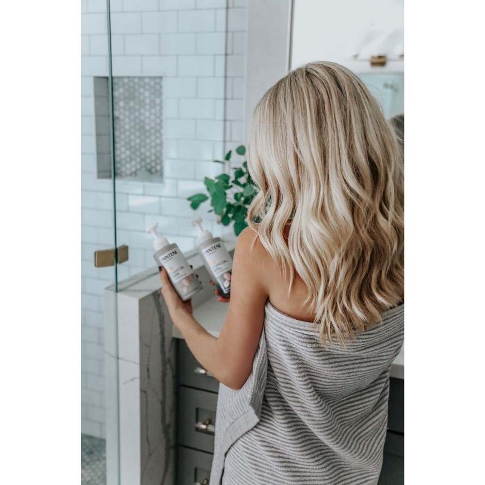 Chica en su baño estilizando su cabello con shampoo