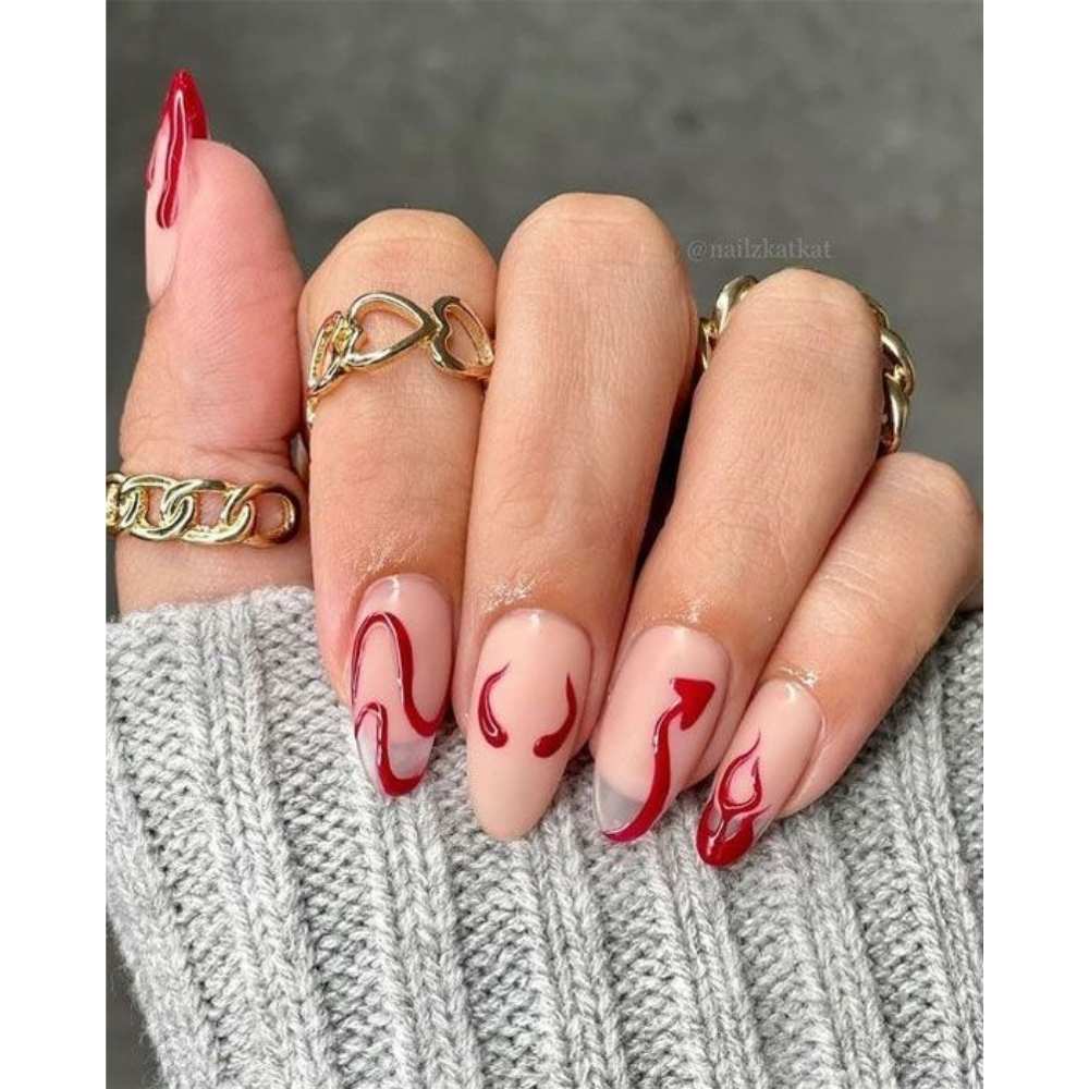 uñas transparentes con diseños de diablito en color rojo