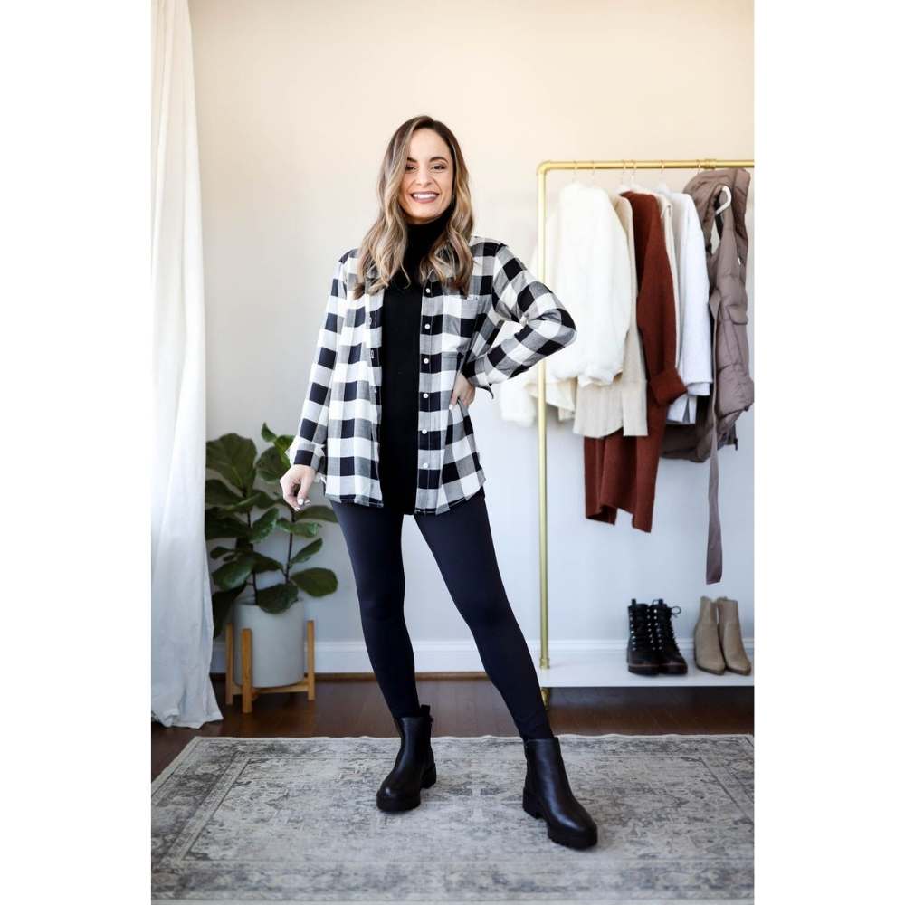 Look con leggins con botines y camisa a cuadros en tonos blanco con negro y suéter cuello tortuga en color negro como base debajo de la camisa