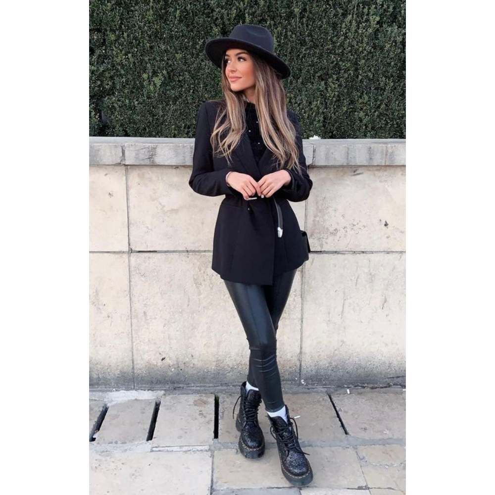 Chica con leggins con botines y blazer en color negro con sombrero de ala ancha