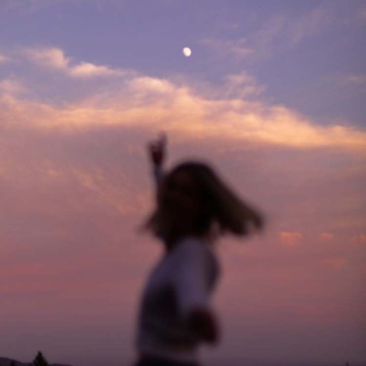 Chica con cabello corto en atardecer debajo de la luna