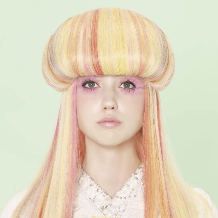 Jellyfish haircut aboltado en la parte de la corona de la cabeza sobre un cabello con mechas de colores rubos, naranjas y rosadas