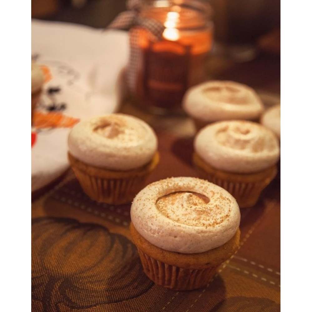 Haz fotografía de los postres típicos de otoño Fotografías de cupcakes de vainilla con canela espolvoreada sobre crema batida
