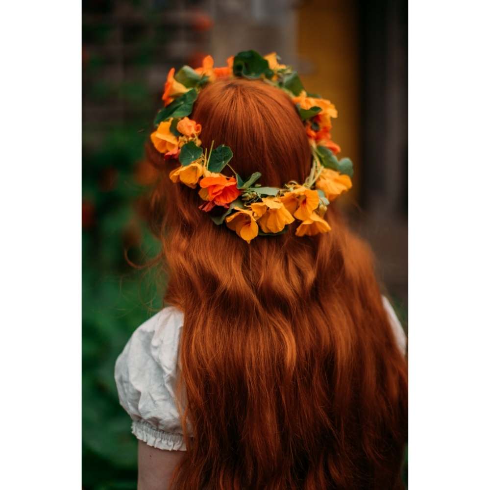 Chica pelirroja con corona de flores naranjas