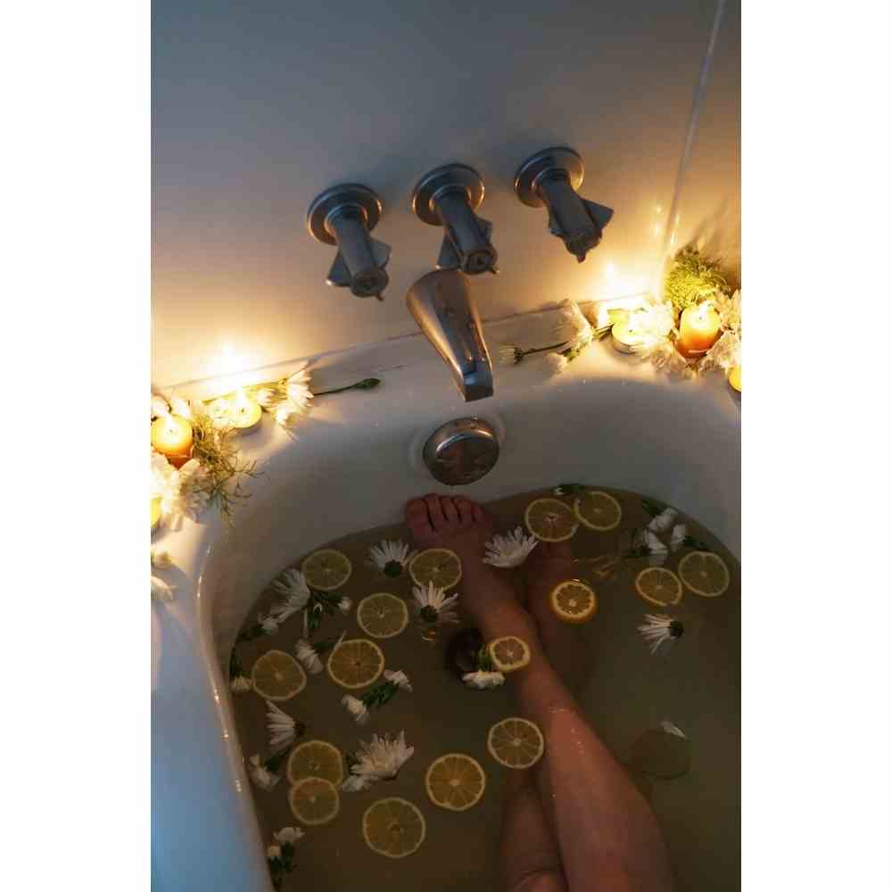 Chica tomando un baño sanador con plantas y esencia