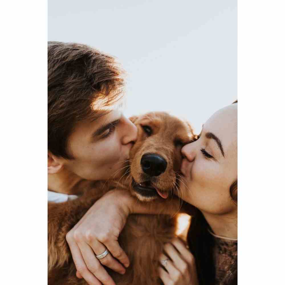 Pareja besando a su perro