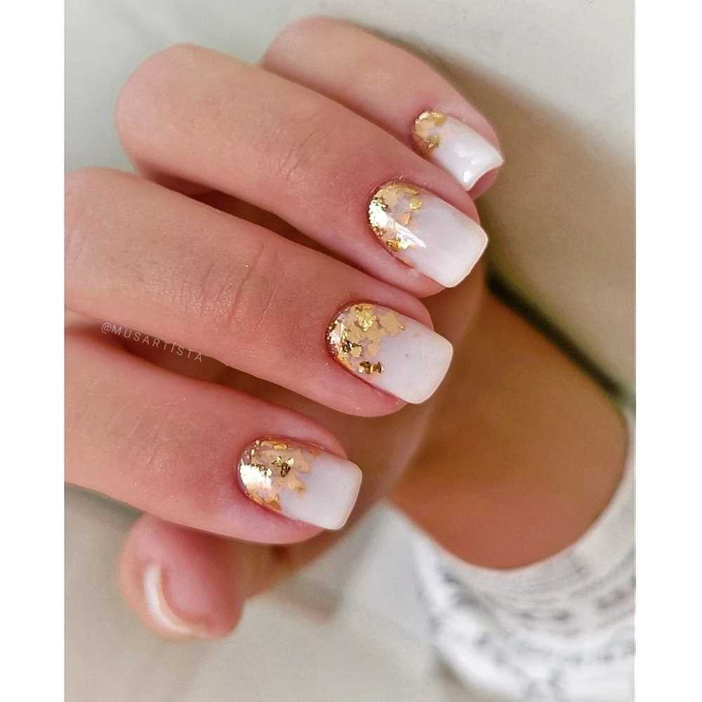 Glitter dorado en francés invertido Uñas doradas con efecto milky ombré