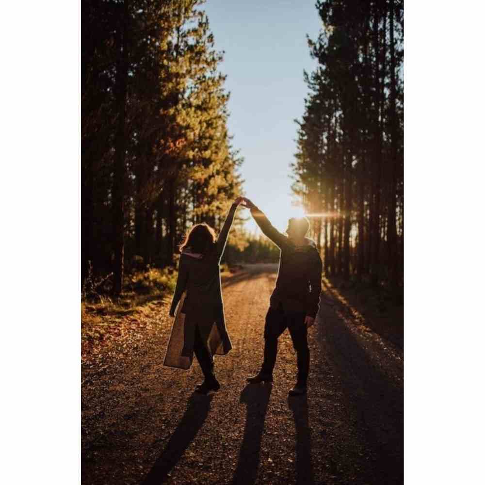 Pareja bailando en un bosque al amanecer