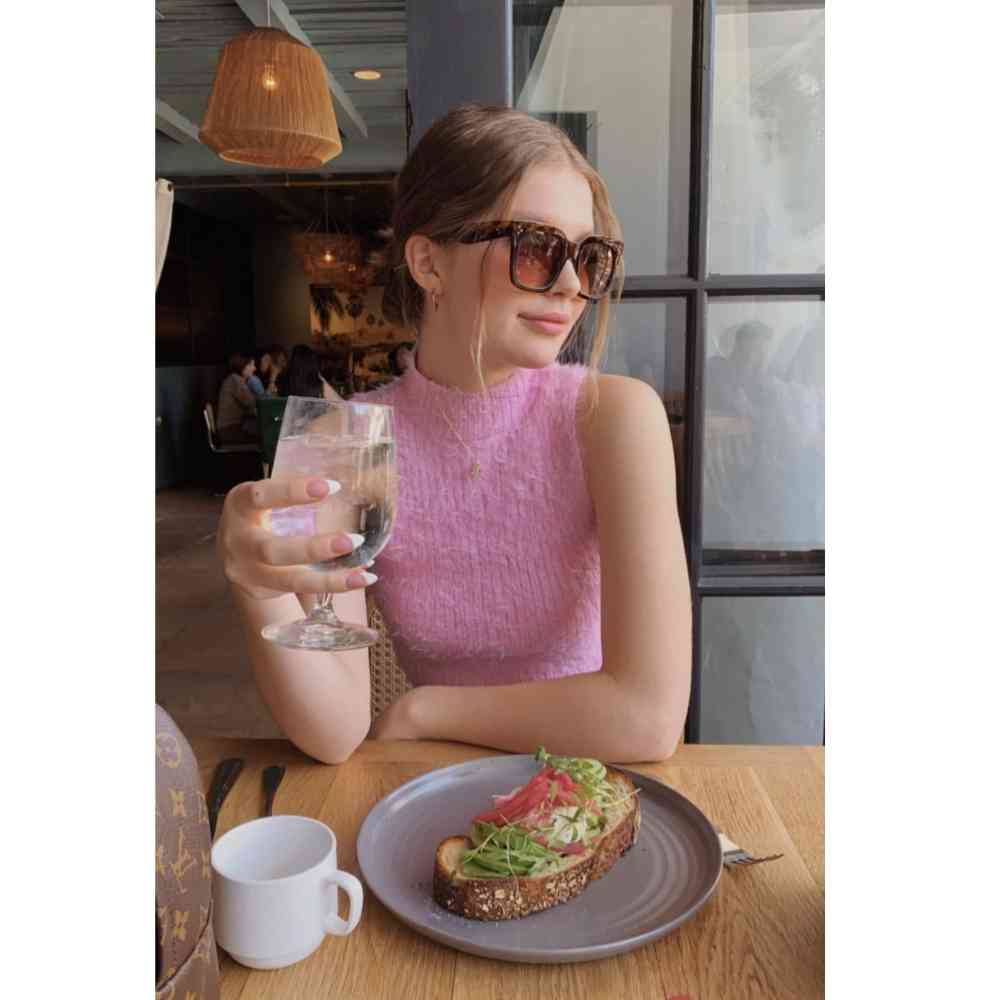 Chica sentada en restaurante comiendo un alimento saludable