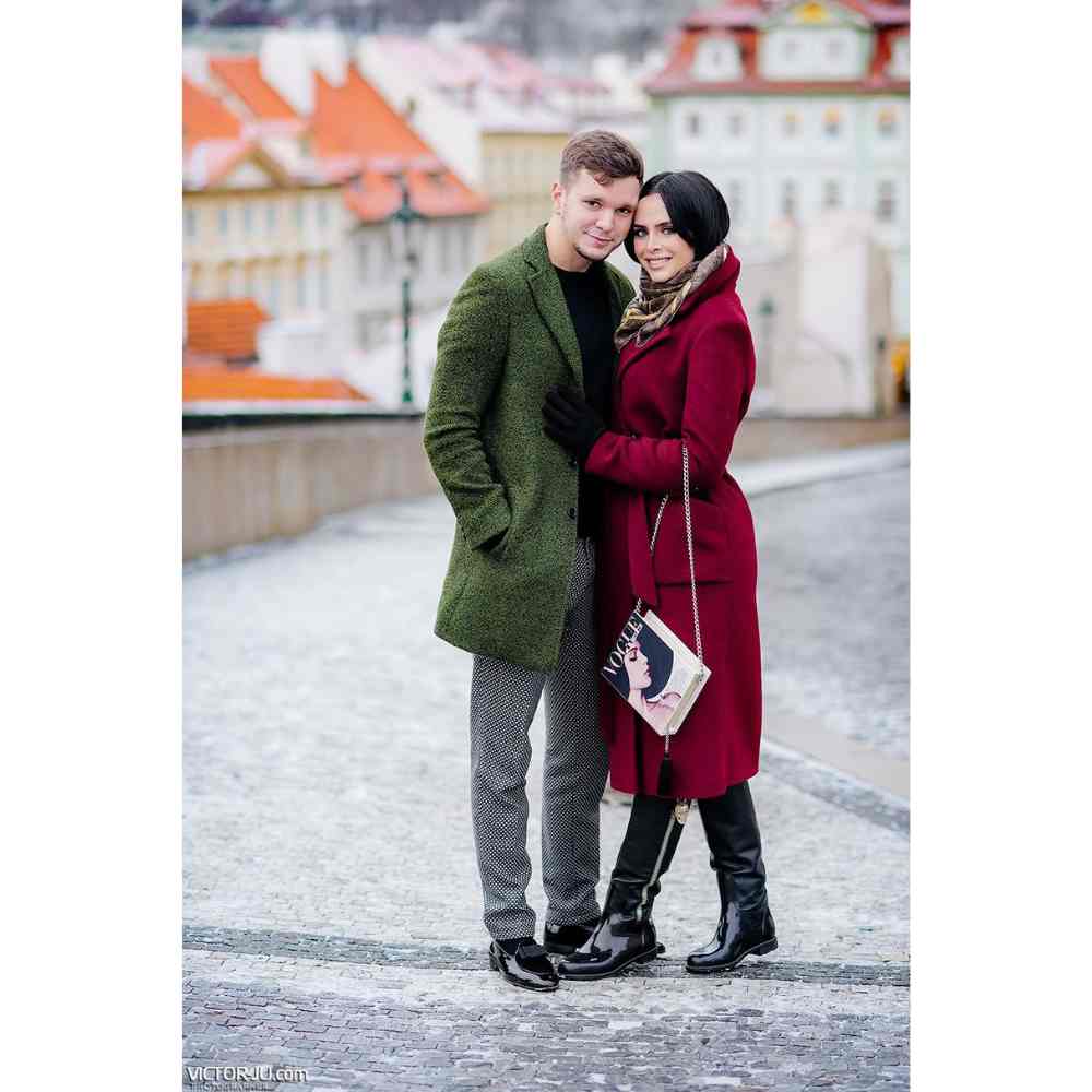 Abrigos largos en contraste con outfit formal Pareja con outfit de abrigos color verde y rojo