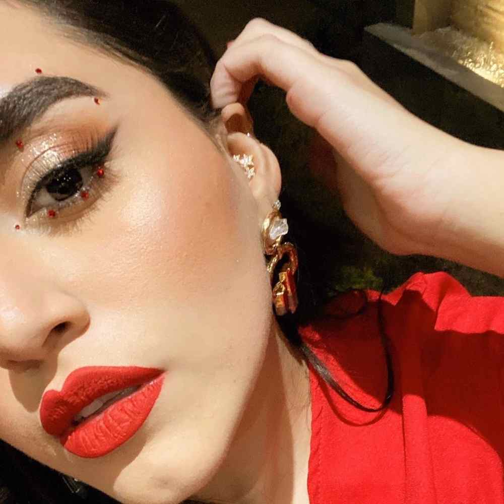 Maquillaje con piedritas rojas y labial rojos