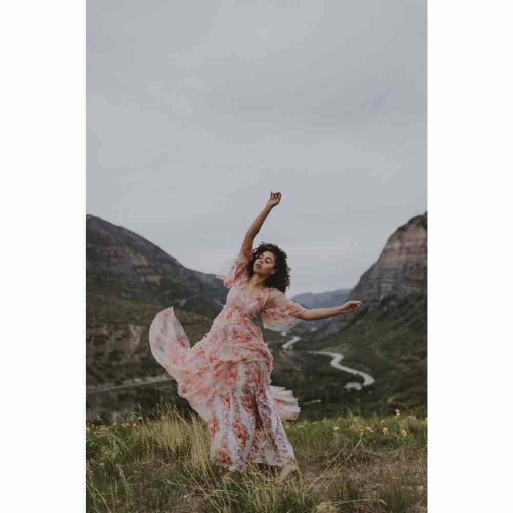 Chica con vestido al viento en una pradera