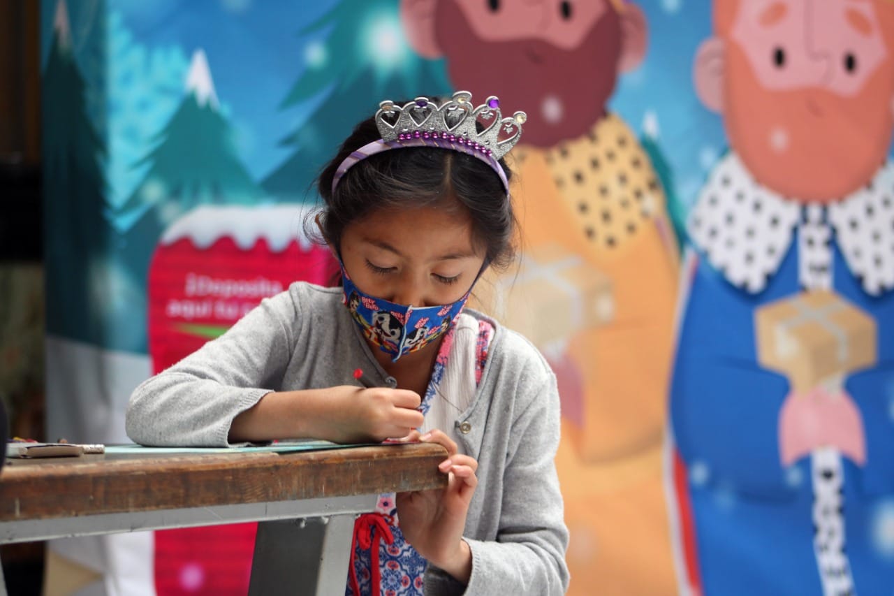 carta a los reyes magos enviada a SEPOMEX niña haciendo su carta para entregarla al sepomex