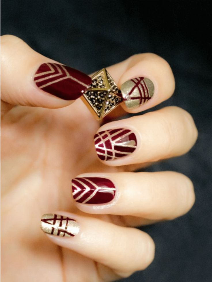 uñas rojas con dorado y diseño 