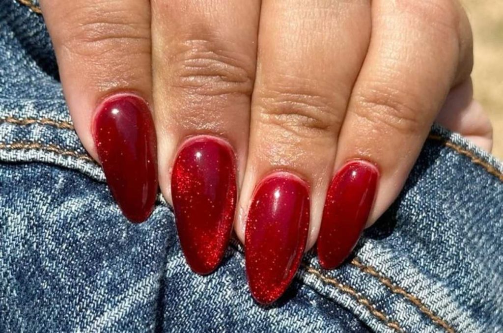 Uñas almendradas con efecto cat eye rojo
