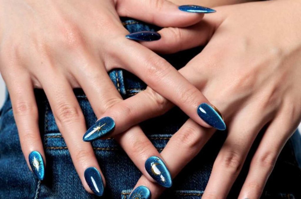 Uñas almendradas en tono azul con efecto cat eye brillante