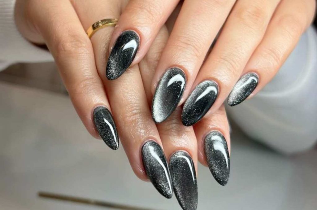 Uñas almendradas en tono plata con efecto cat eye brillante