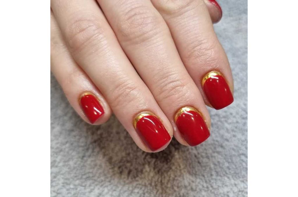 uñas rojo con dorado francesa invertida