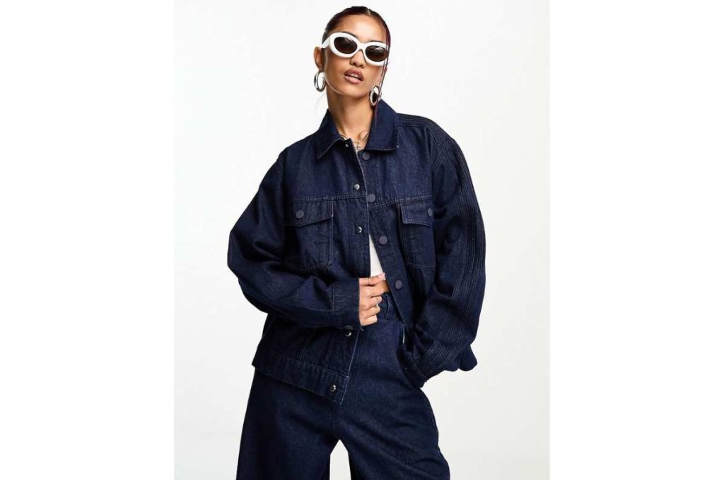 Mujer con chaqueta oversized de mezclilla oscura combinada con crop top