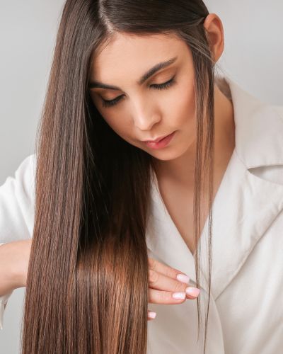 Mujer luce un pelo sedoso tras tratamiento de alisado de cabello