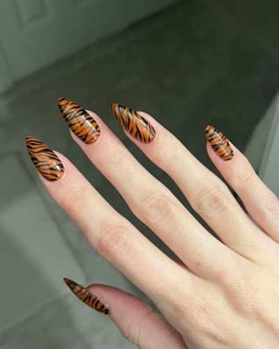 Uñas decoradas con diseño de efecto jaguar en tonos marrón y negro