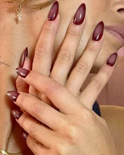 Uñas pintadas de color morado con brillo brillante