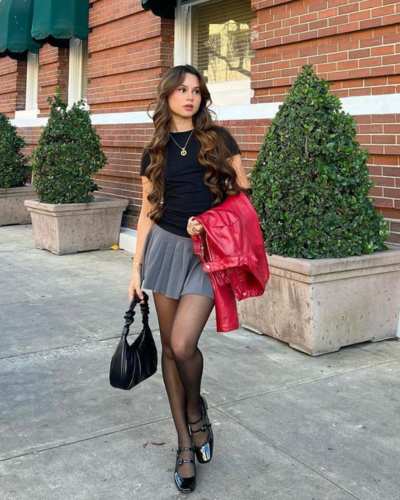 Outfit con falda plisada, blusa de manga corta y chaqueta de cuero 