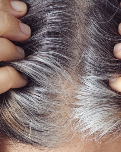 Mujer con canas en el cabello por no teñir el pelo correctamente