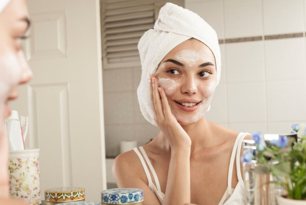 “Chica con mascarilla facial relajándose durante su rutina de cuidado de la piel”