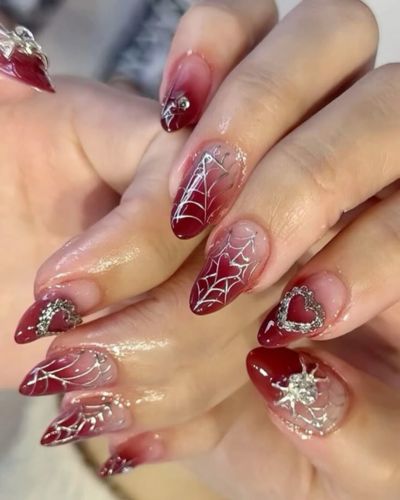 Manicura con efecto degradado en color rojo y detalles metálicos