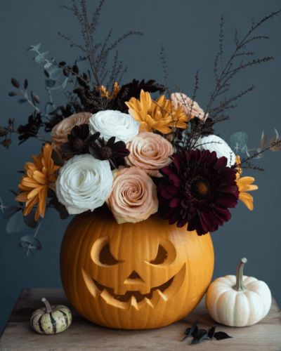 calabaza sobre una mesa decorada con flores para halloween