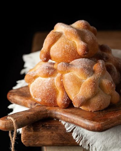 Historia del pan de muerto: 3 piezas sobre una tabla de madera