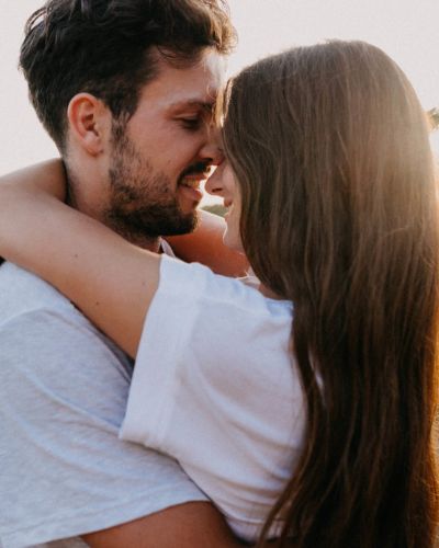 Hombre abraza a su pareja y le da un beso en la frente