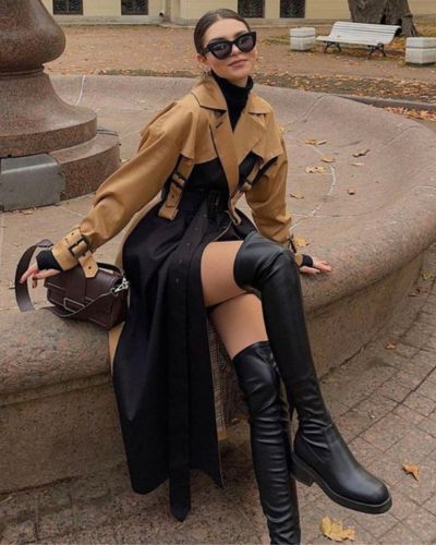 Cropped de cuero en color mostaza, vestido largo de satén en color negro y botas negras altas