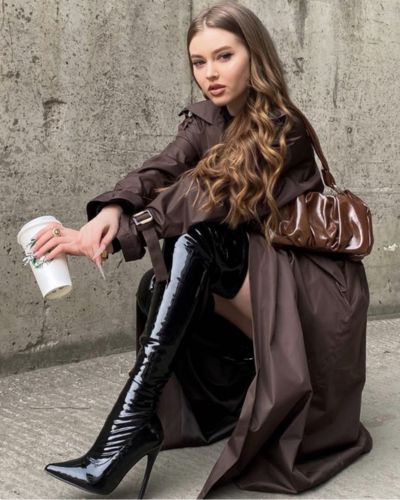 Look con gabardina café y botas negras altas