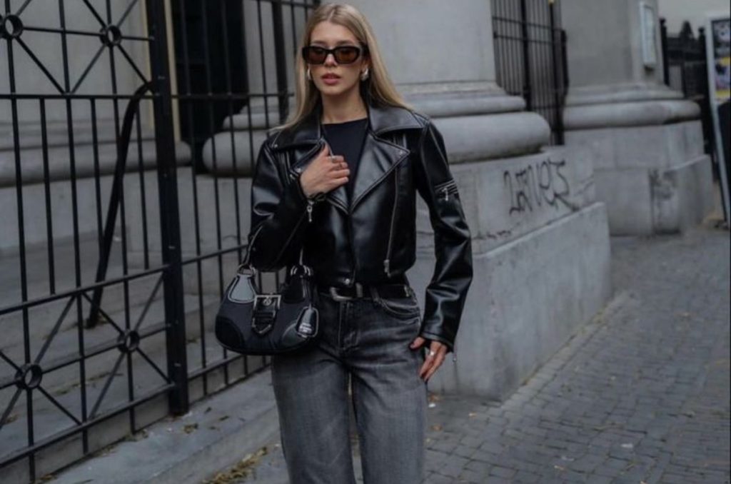 Chamarra negra, top negro y pantalón sastre gris