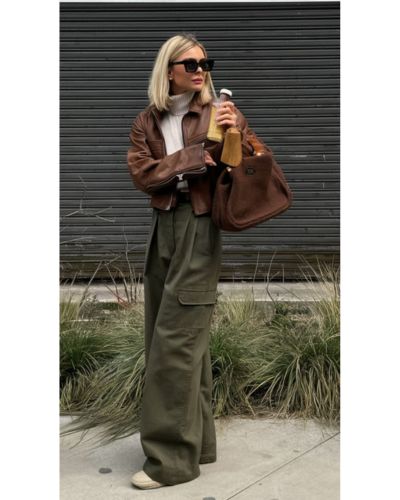 Chamarra de piel en color café junto a pantalones cargo en color verde y top blanco