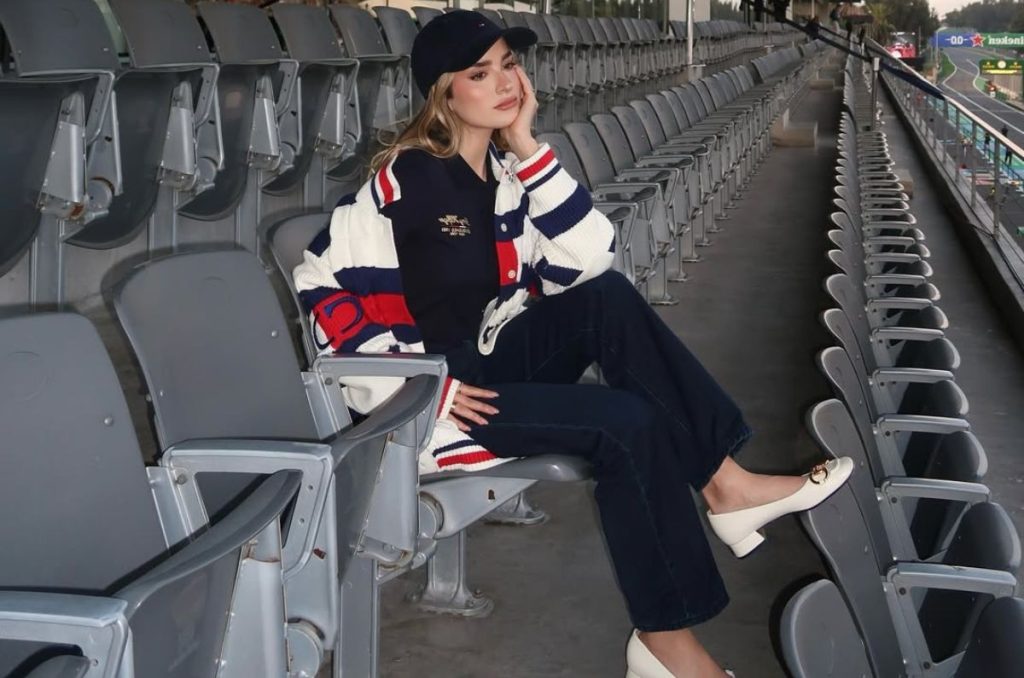 Outfit con pantalones denim, camisa polo oscura, suéter blanco con franja azul y roja, y flats blancos