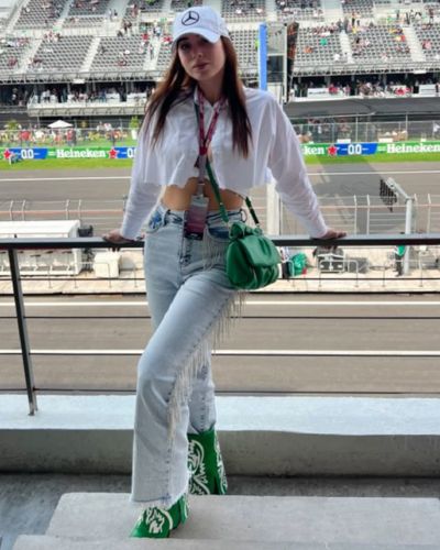 Pantalón wide leg, camisa blanca de botones, gorra de la Fórmula 1 y bolsa y tenis color verde