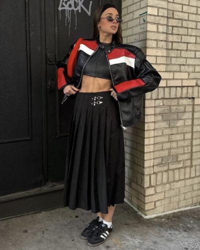 Falda midi en color negro, top negro, chaqueta de cuero y tenis negros