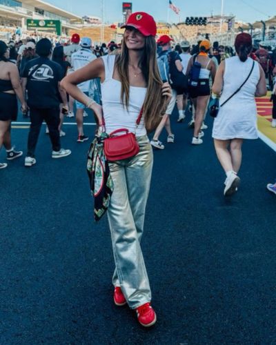 Pantalón metálico con tanker top blanco y gorra y tenis rojos 