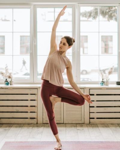 Mujer practicando la postura del árbol (Vrksasana)