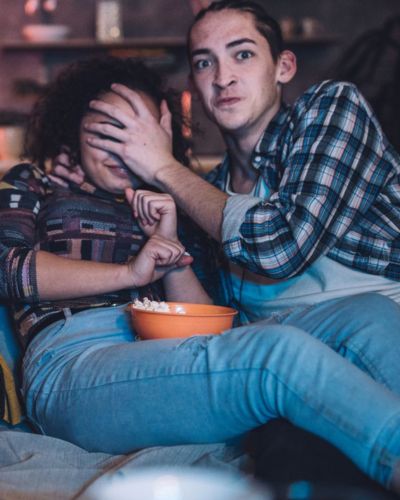 Pareja viendo películas de terror en sofá